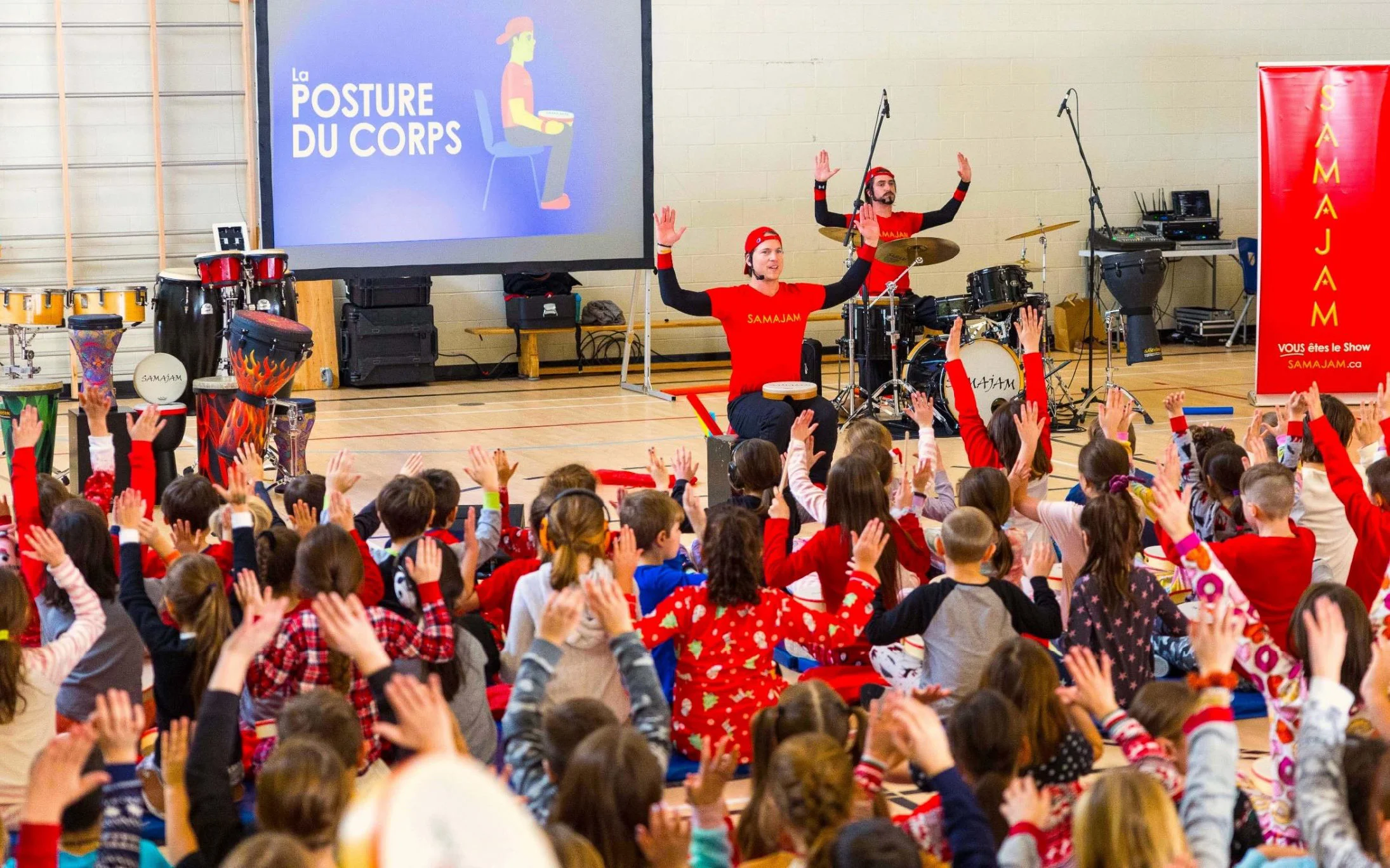 Two SAMAJAM artists lead a gymnasium full of students