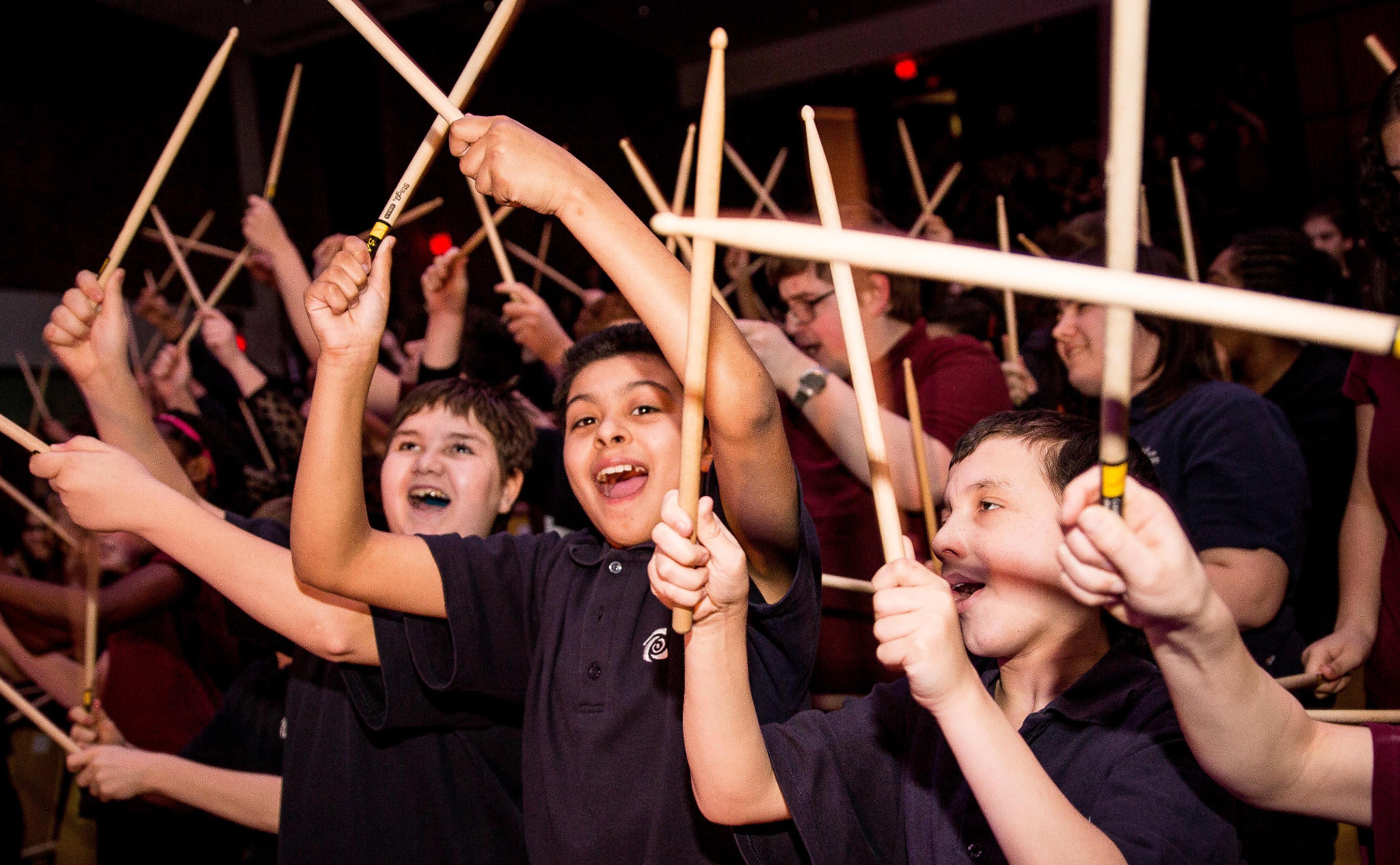 Enfants participant à une activité scolaire SAMAJAM avec des baguettes.