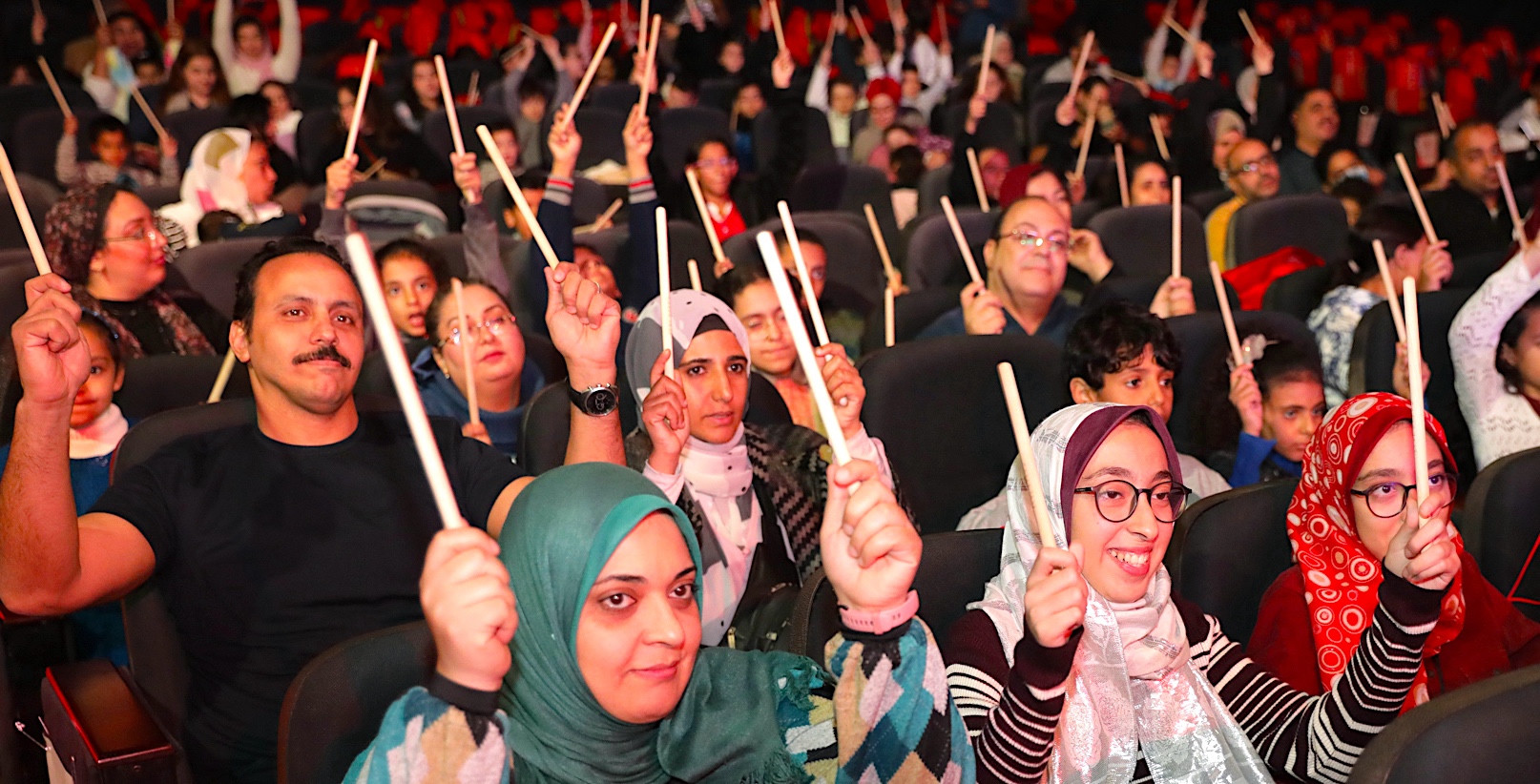 Public en Égypte participant au spectacle SAMAJAM avec des baguettes.